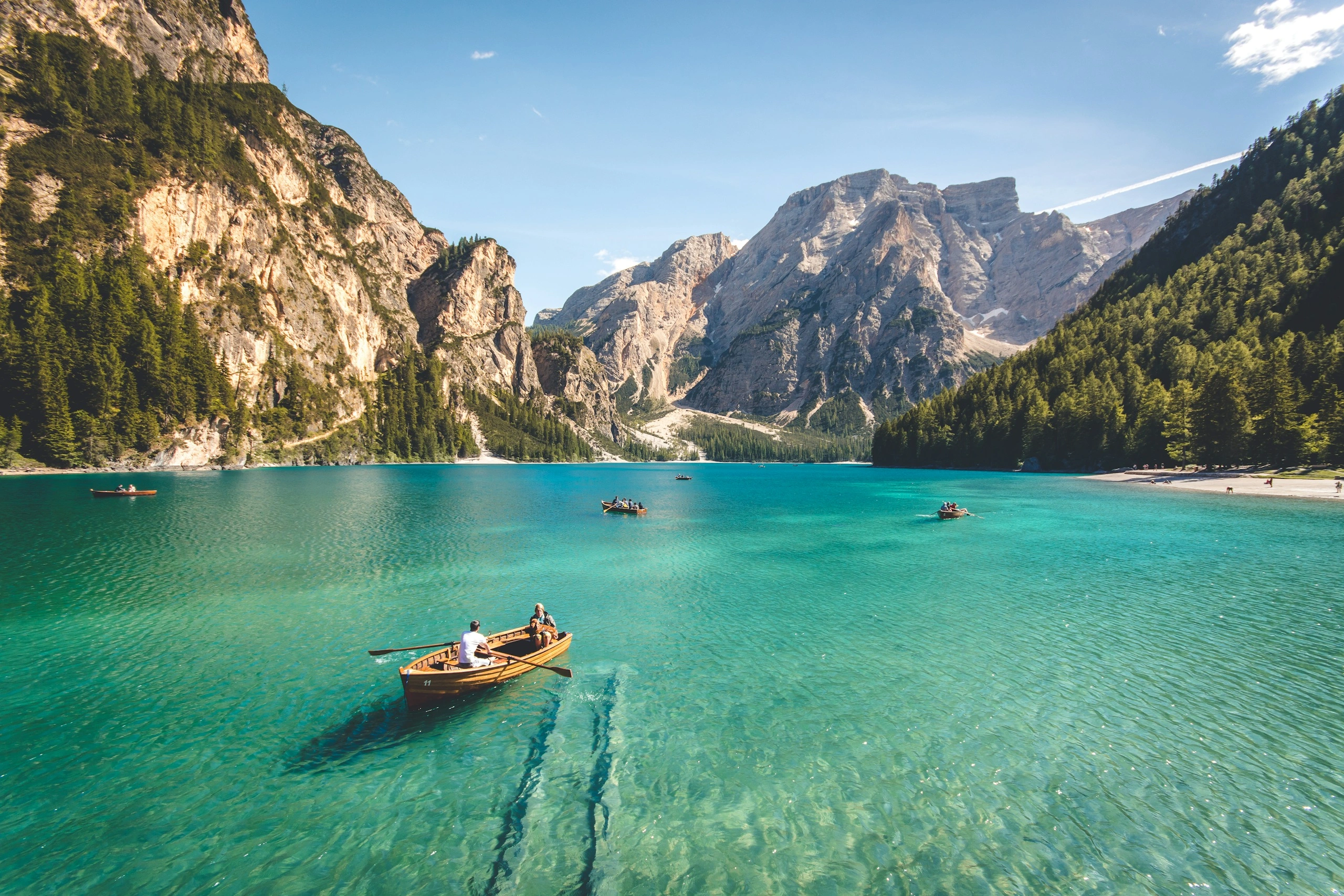 Un lac turquoise entouré de montagnes et de forêts.